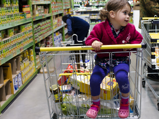 Little girl sitting in shopping trolley in Pak n Save