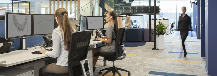 Two women working at hot desks