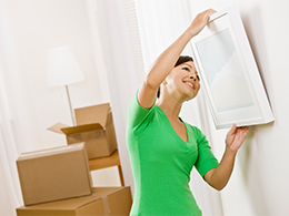 Woman removing picture frame from the wall